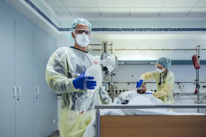Portrait of doctor in emergency care unit of a hospital holding bag valve mask